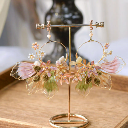 Catriona lavender resin floral earrings on a gold display stand showing petal and leaf detail
