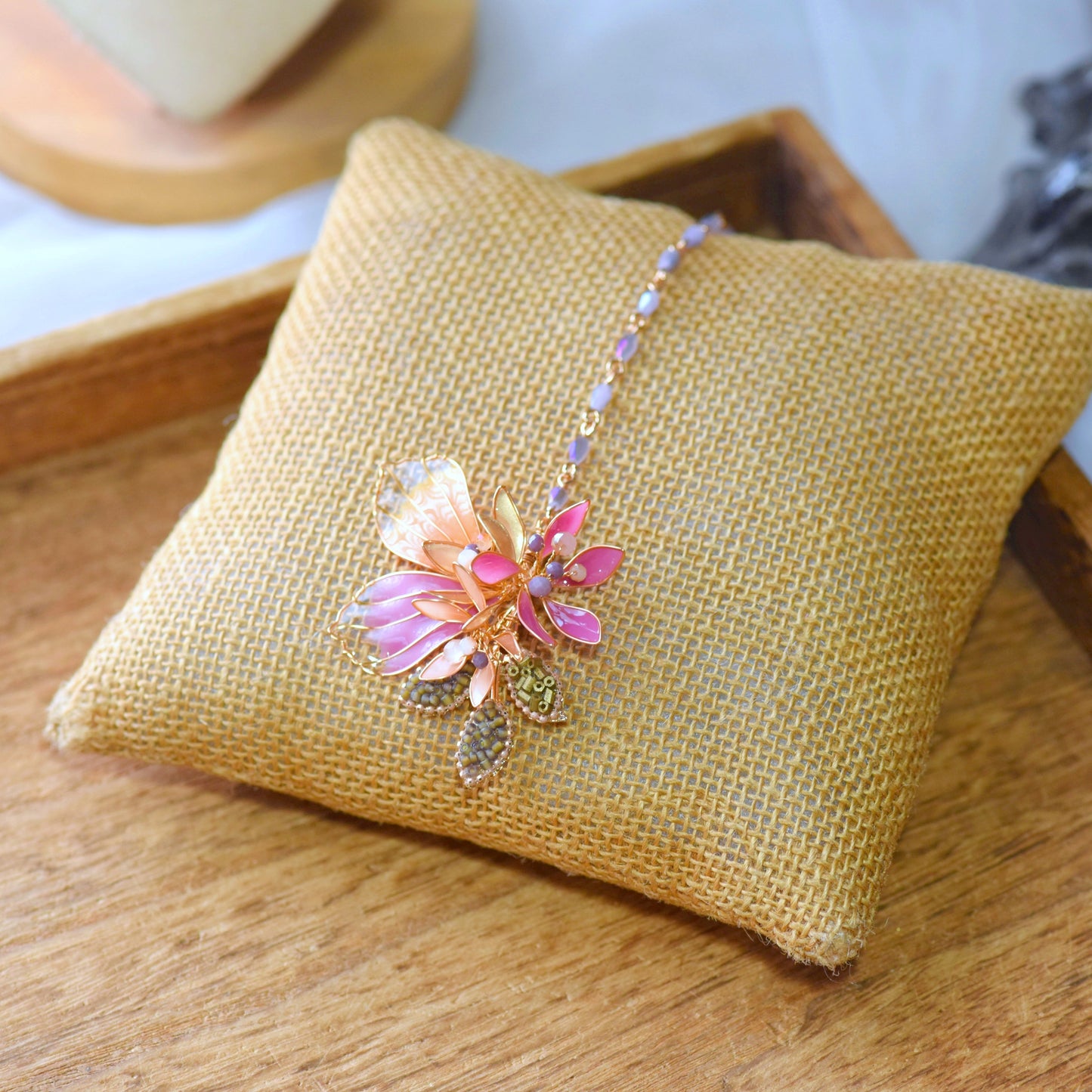 Catriona handcrafted resin floral maang tika pink orange lavender gold beaded chain flat lay burlap cushion
