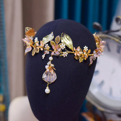 Catriona floral head harness displayed with matching earrings on a dark stand
