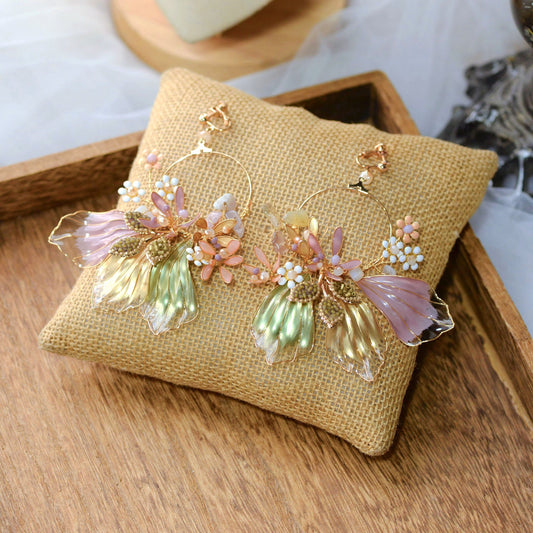 Catriona lavender and green resin floral bridal jewellery set with necklace and earrings on a jute cushion
