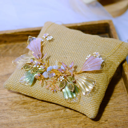 Catriona lavender and green resin floral necklace with golden wirework laid on a jute cushion
