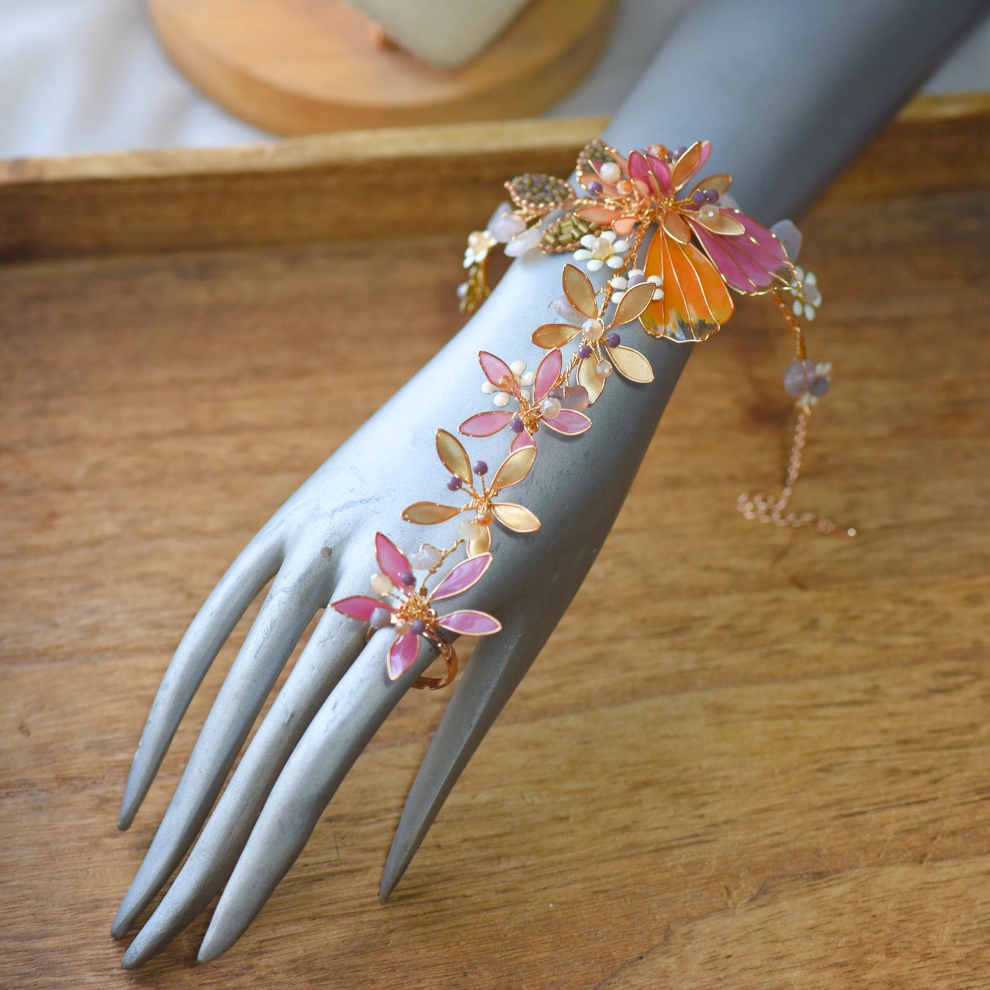 Catriona handcrafted resin floral hath phool hand harness pink orange gold copper wire on model hand detail
