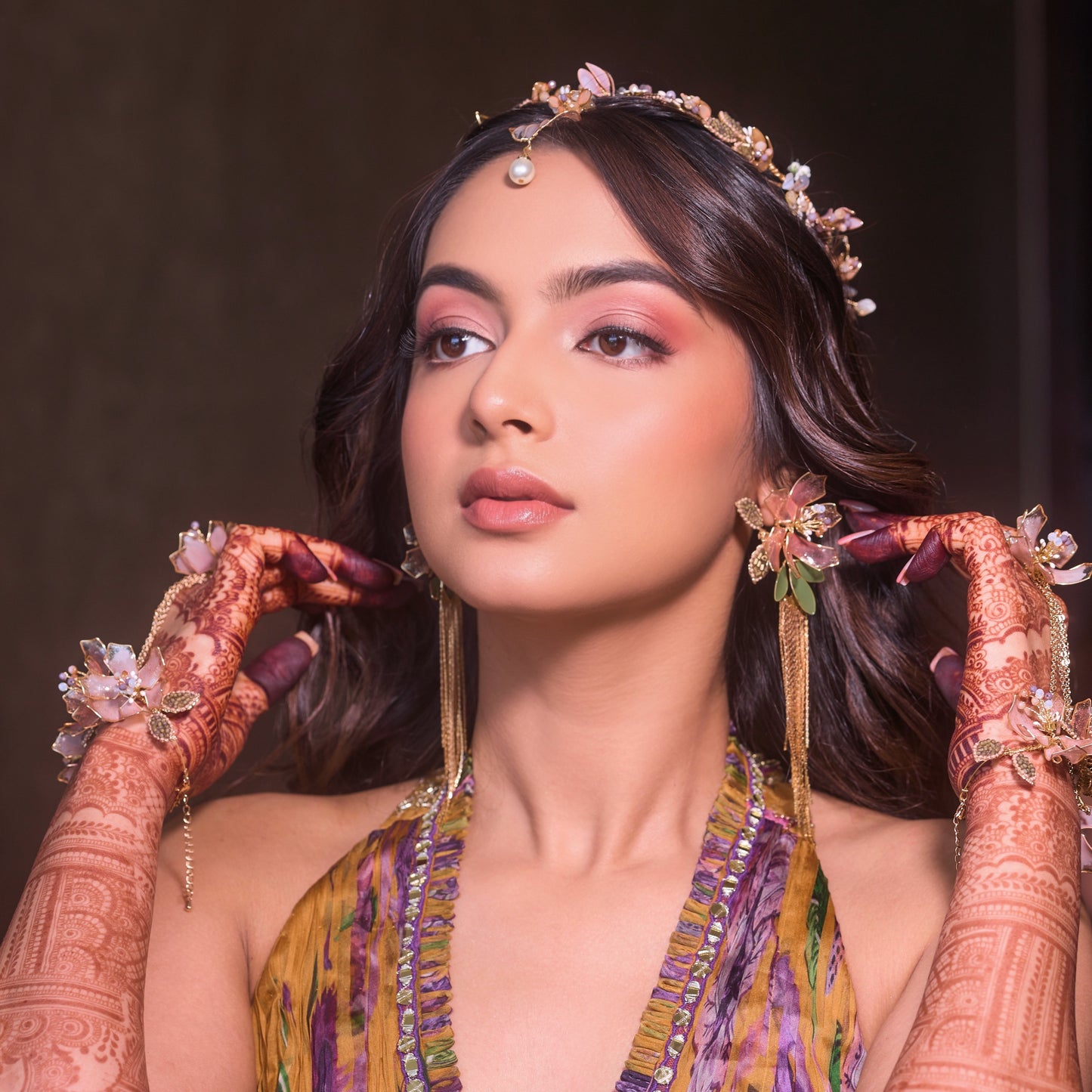 Model wearing Celestina handcrafted resin floral drop earrings and headband pink gold with mehendi bridal look

