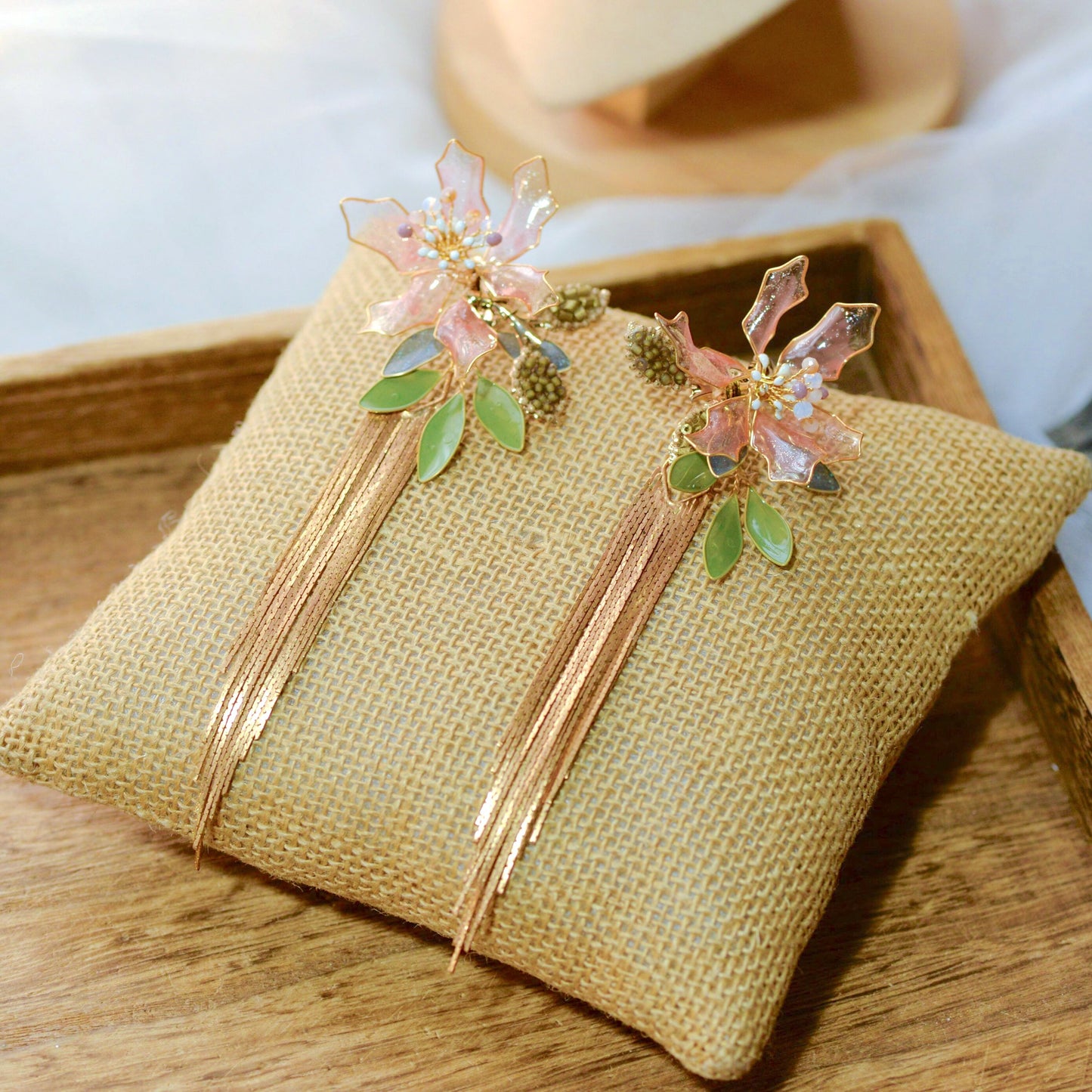 Celestina handcrafted resin floral drop earrings pink gold flat lay burlap cushion detail
