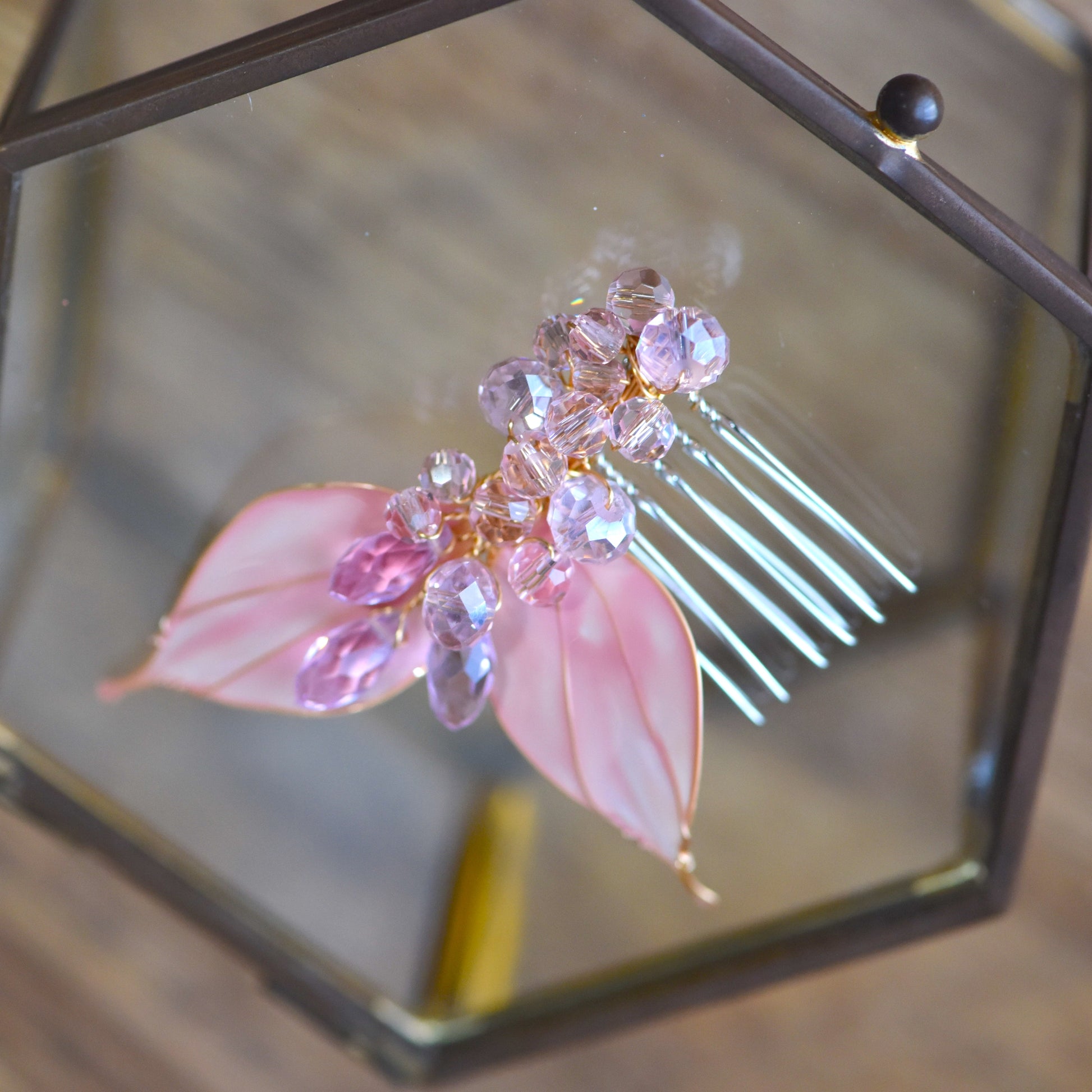 Close-up of Celine floral hair clips showing translucent pink resin leaves, faceted crystal beads and handcrafted gold wire finish