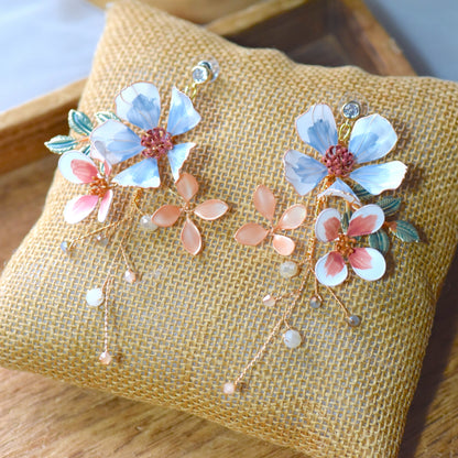 Close up of Clara floral earrings with pastel blue and pink resin petals