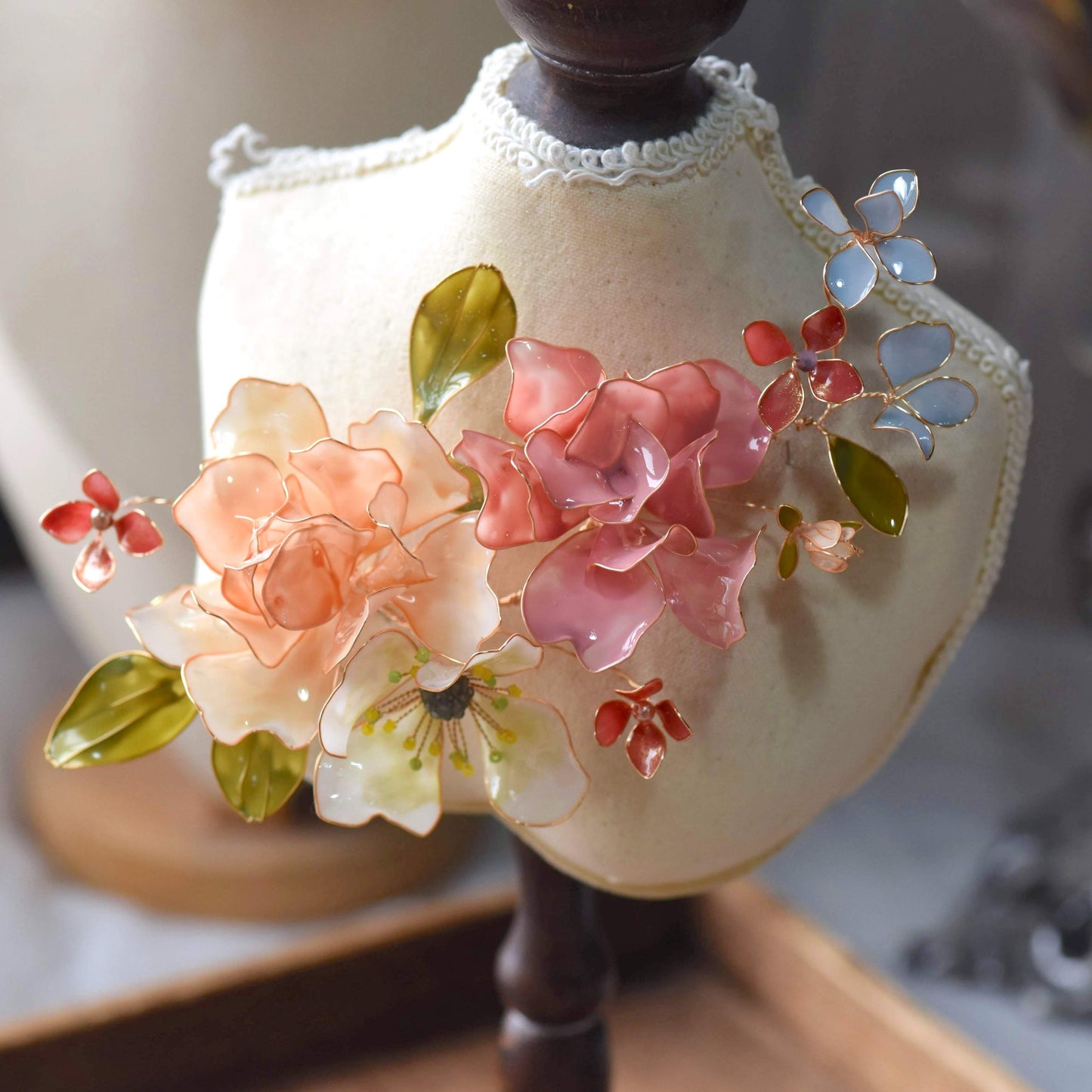 Cora handcrafted resin floral hair piece blush pink peach ivory coral dark red green blue-grey flat lay burlap
