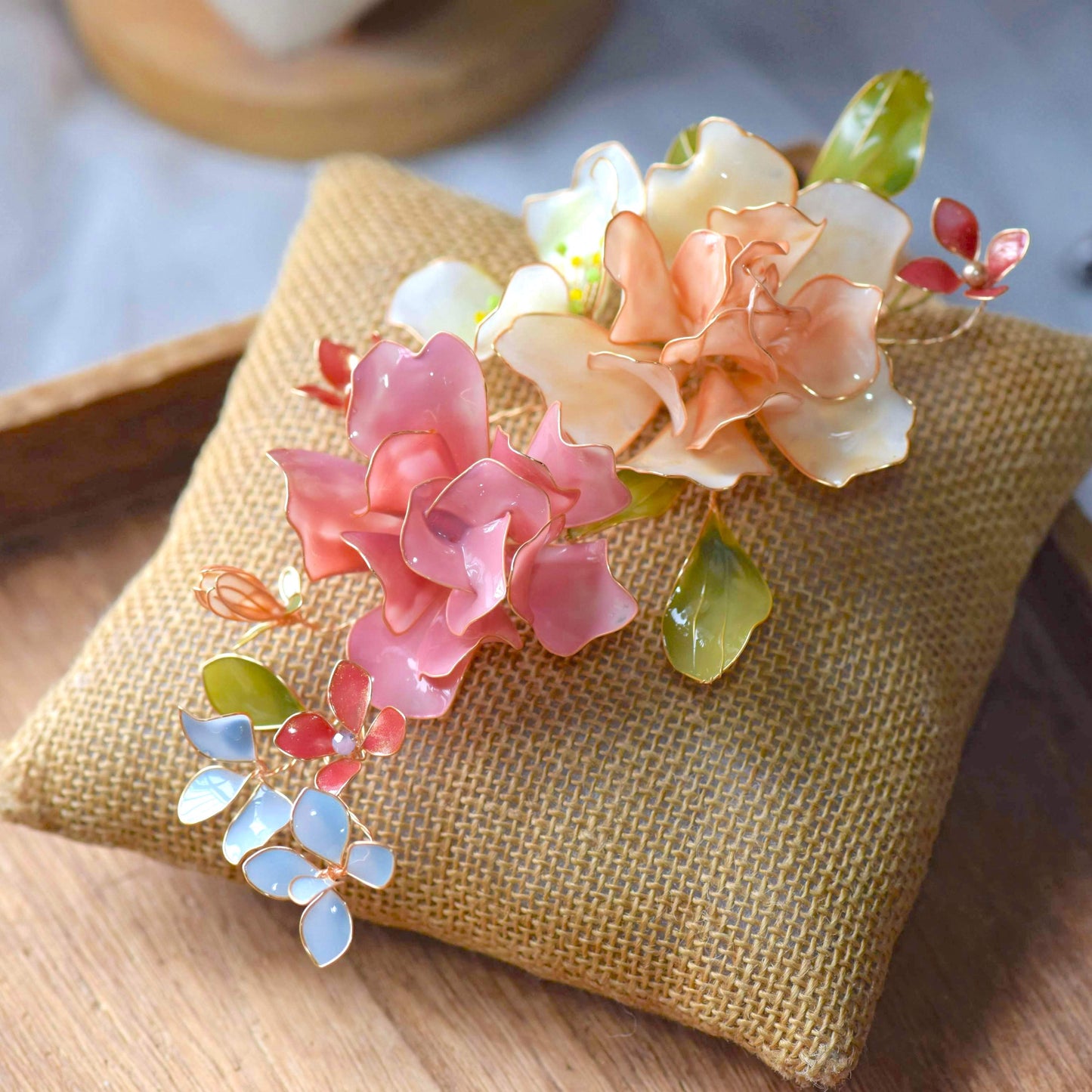 Cora handcrafted resin floral bridal hair accessory blush pink peach coral green blue-grey on white bust
