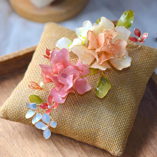 Cora handcrafted resin floral bridal hair accessory blush pink peach coral green blue-grey on white bust
