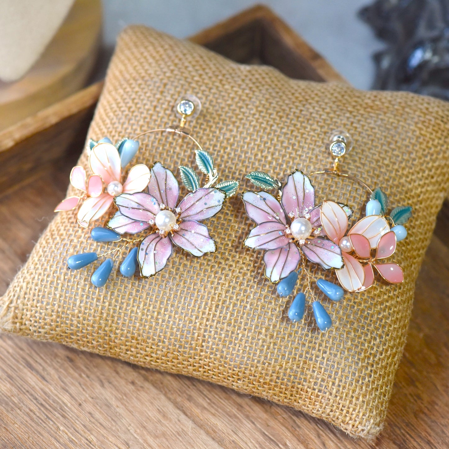 Close up of handcrafted Dahlia earrings with blush pink petals and botanical details