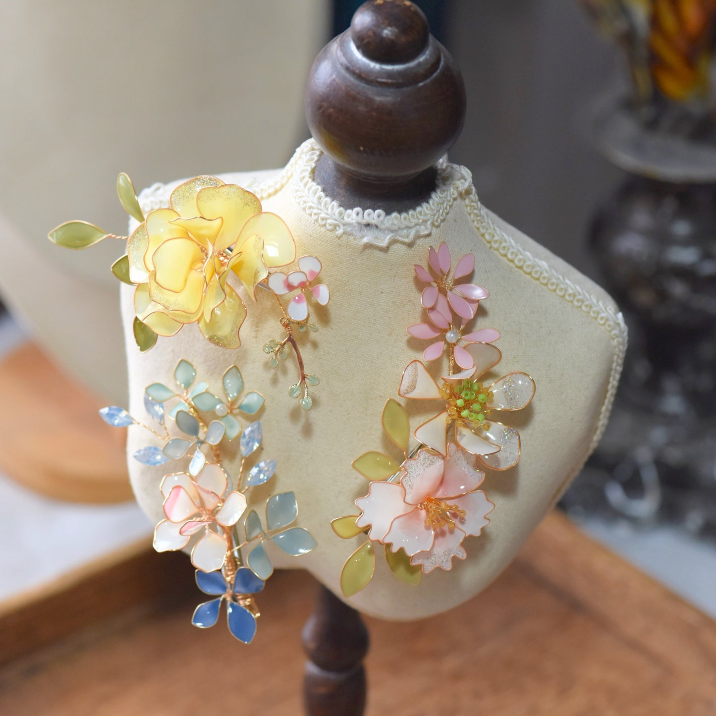 Close-up of Elena floral hair accessory featuring pastel resin petals and delicate gold wirework
