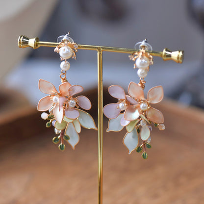 Elowen blush and mint resin floral statement earrings on a display stand showing layered petals
