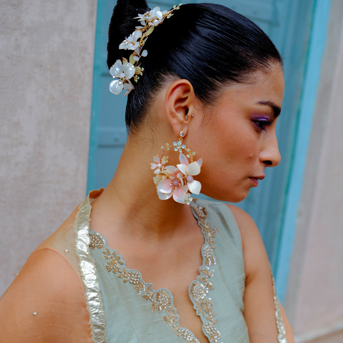 Model wearing Elvyne white resin floral statement earrings with an ivory ensemble
