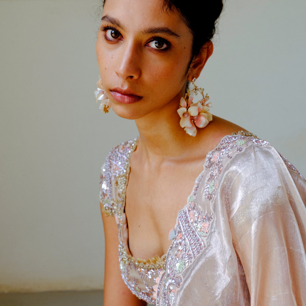 Model in ivory bridal wear wearing the Elvyne white and pink floral earrings
