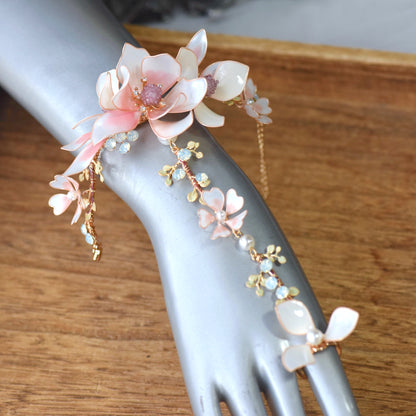 Elvyne white and pink floral haath phool on a display hand showing the wrist-to-finger vine
