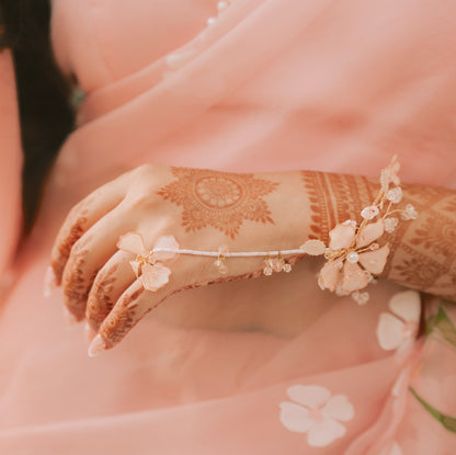 Real bride's henna-decorated hand wearing the Eos blush pink floral haath phool
