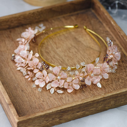 Eos blush pink floral headband laid flat on a wooden tray showing the full crown of blooms

