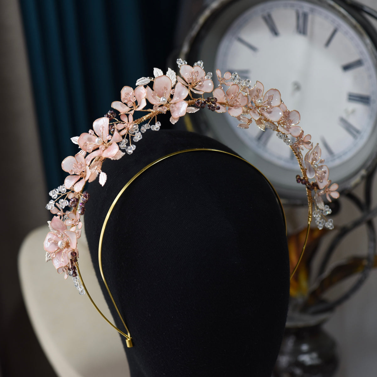 Close view of the Eos headband showing blush pink resin blooms and purple bead accents
