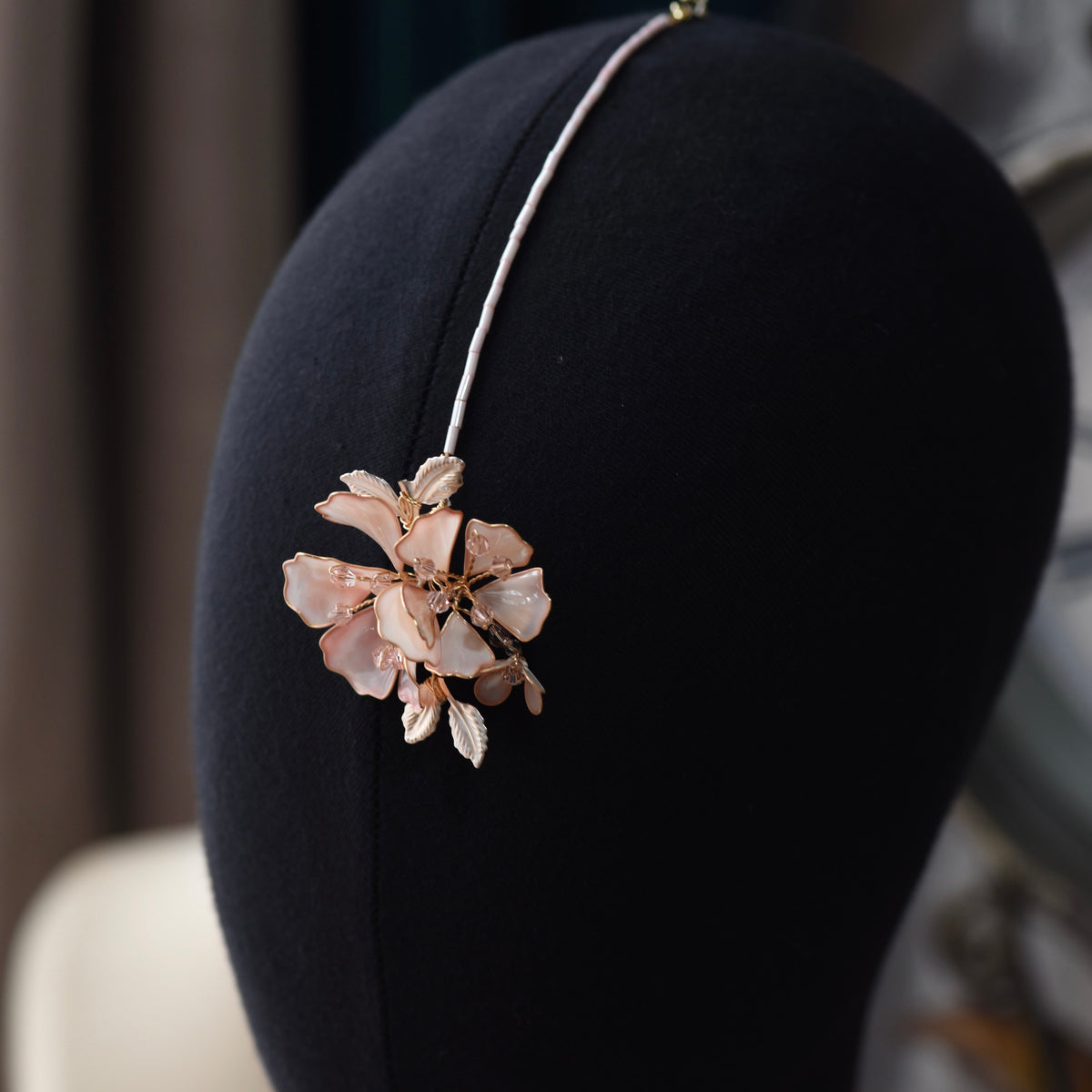Close view of the Eos maang tika showing the blush pink resin bloom and fine chain

