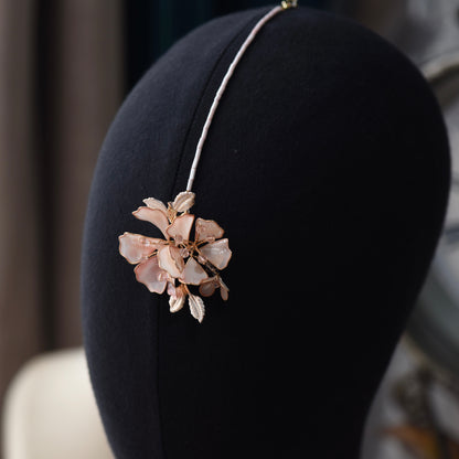 Close view of the Eos maang tika showing the blush pink resin bloom and fine chain

