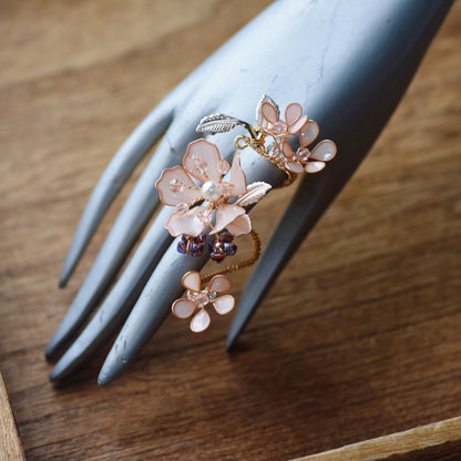 Eos blush pink floral ring on a display hand showing the sculpted bloom and adjustable band

