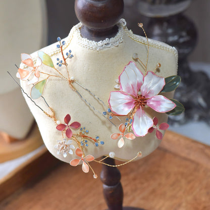 Close-up of Esmeralda floral hair accessory showing translucent resin petals, pastel foliage and intricate gold wirework