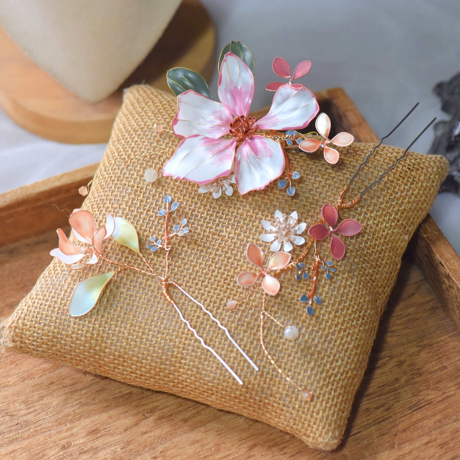 Esmeralda handcrafted floral hair accessory featuring blush pink and ivory resin petals with gold detailing