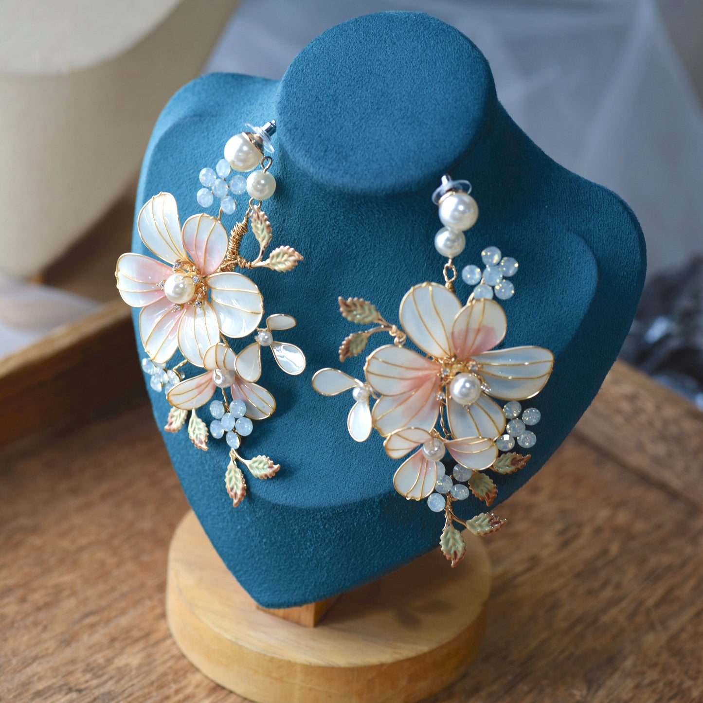 Florence blush pink white and mint resin floral statement earrings on a navy display stand
