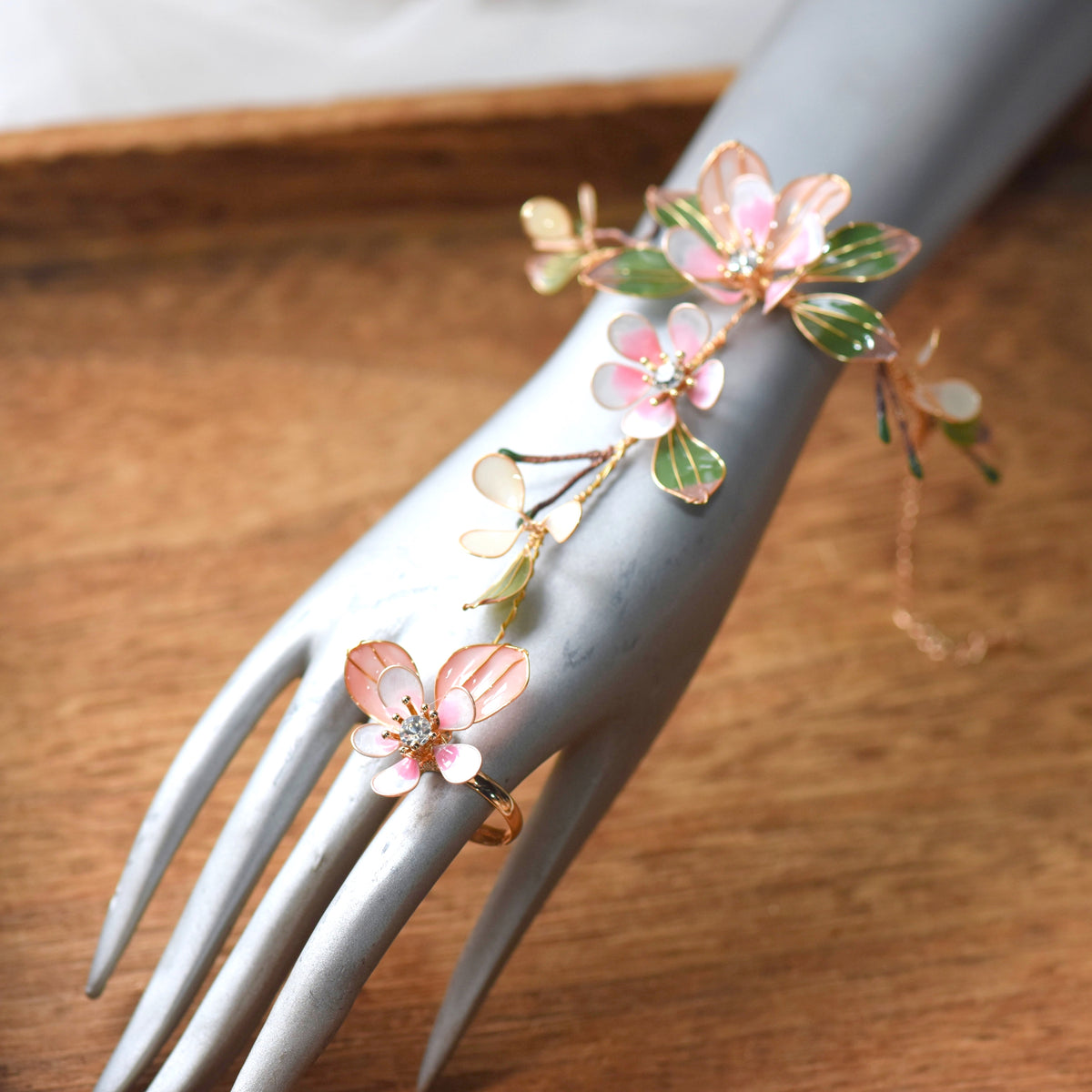 Florentine blush pink floral haath phool on a display hand showing the wrist-to-finger vine
