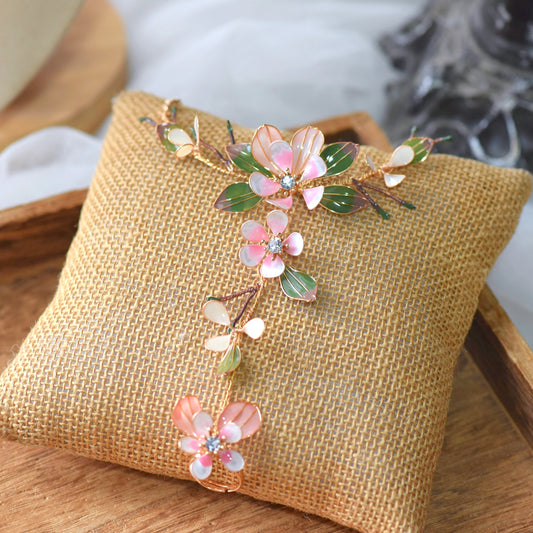 Florentine blush pink resin floral hand harness with olive leaves laid on a jute cushion
