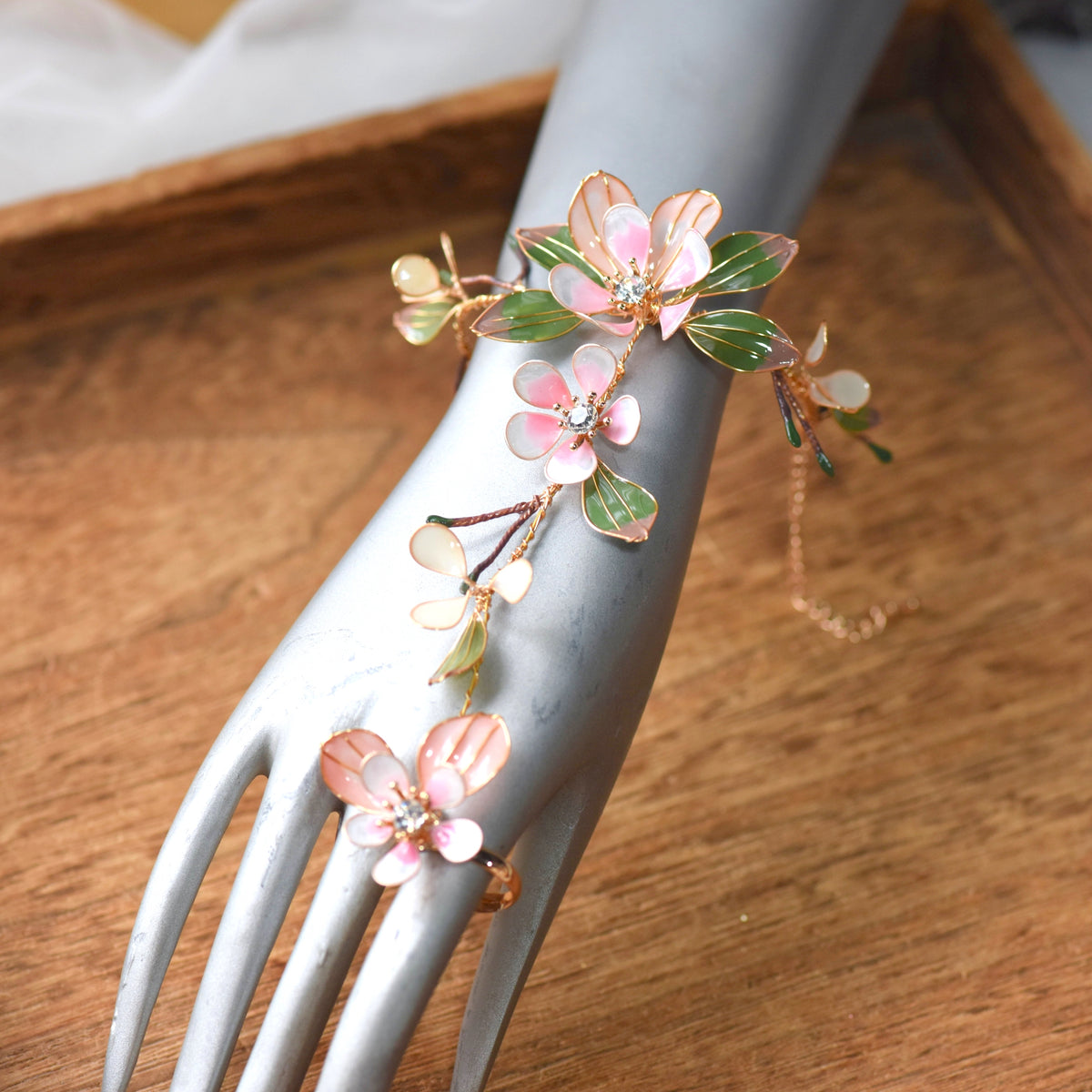 Close view of the Florentine hand harness showing blush petals with zirconia centres
