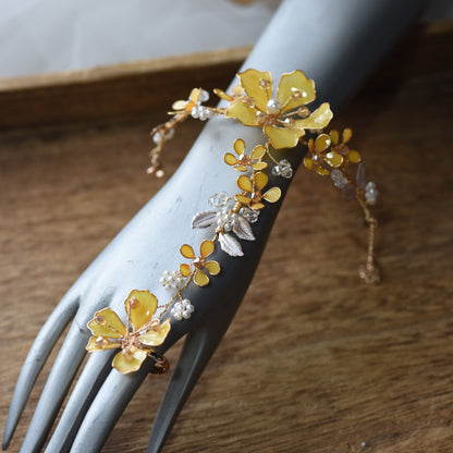 Helios yellow floral haath phool on a display hand showing the wrist-to-finger design
