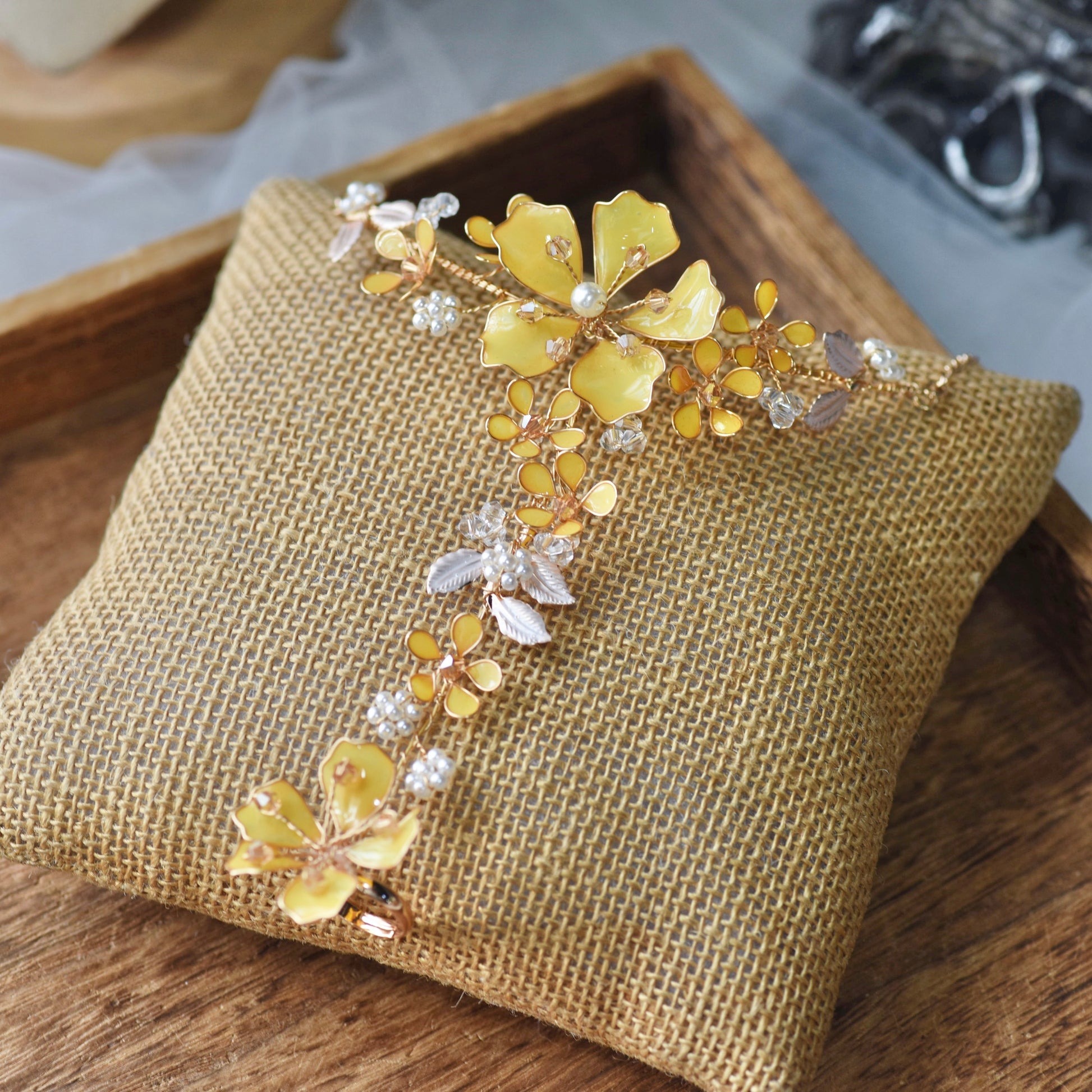 Helios yellow resin floral hand harness with golden accents laid on a jute cushion
