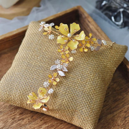 Helios yellow resin floral hand harness with golden accents laid on a jute cushion

