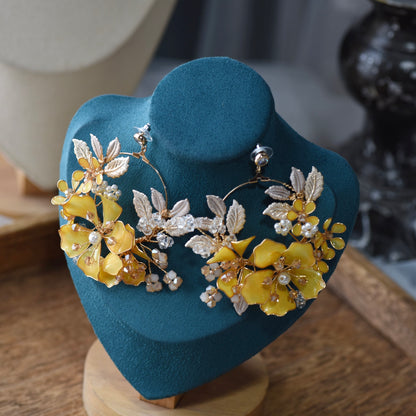 Helios yellow floral statement earringsfrom the jewellery set on a display stand
