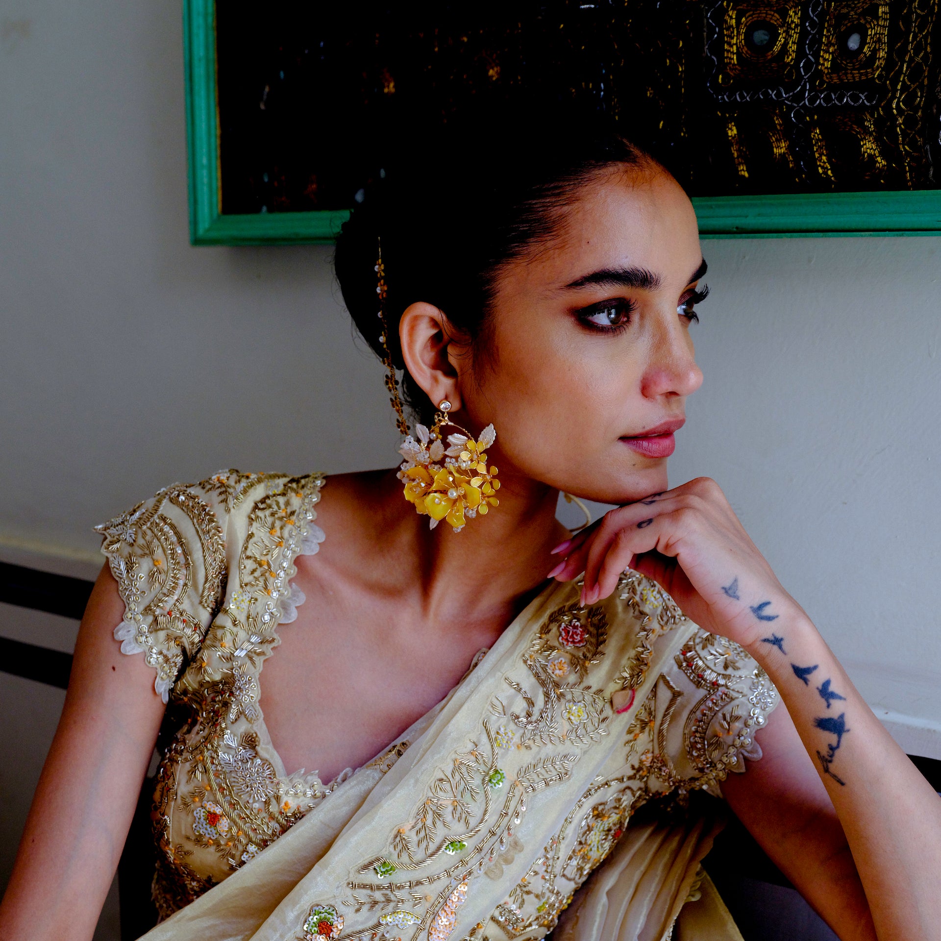 Close view of Helios yellow resin floral earrings worn with a gold-toned outfit
