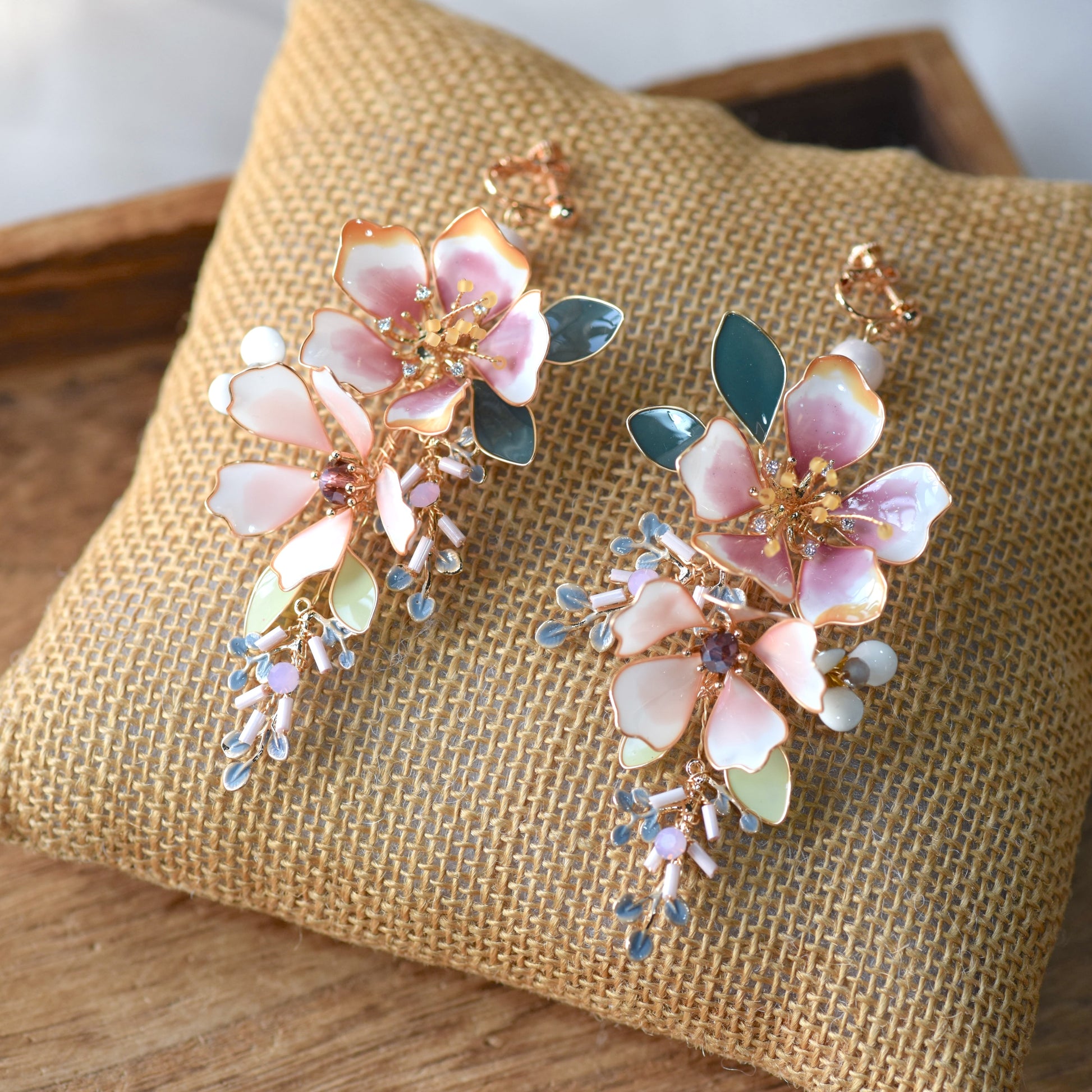 Imogen handcrafted blush pink resin floral drop earrings watercolour gradient crystal pale blue grey bead clusters flat lay burlap
