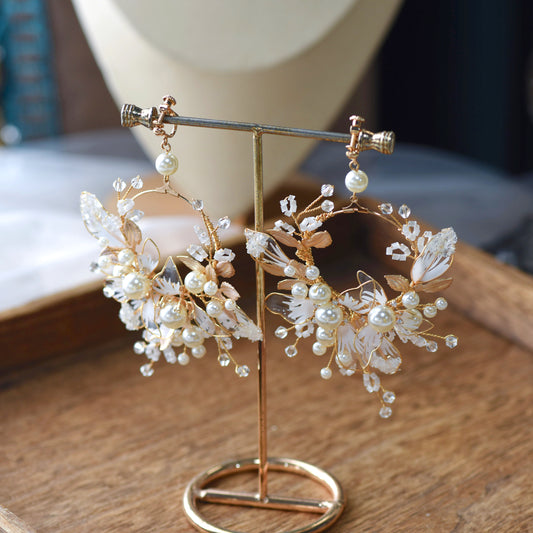 Juliana white resin floral earrings with imitation pearls on gold display stand

