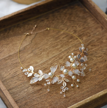 Juliana white resin floral necklace with imitation pearls and gold accents on display
