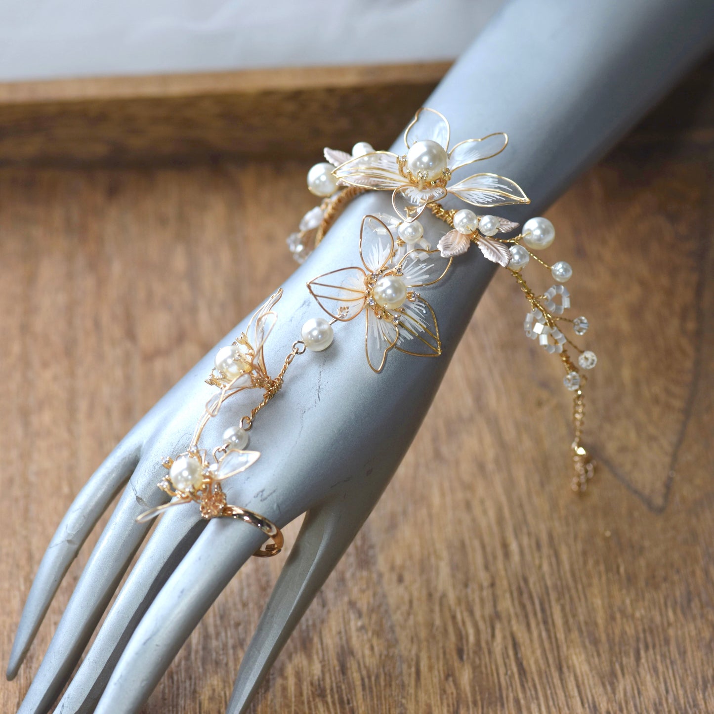 Juliana white and pearl resin floral haath phool worn from wrist to finger on hand
