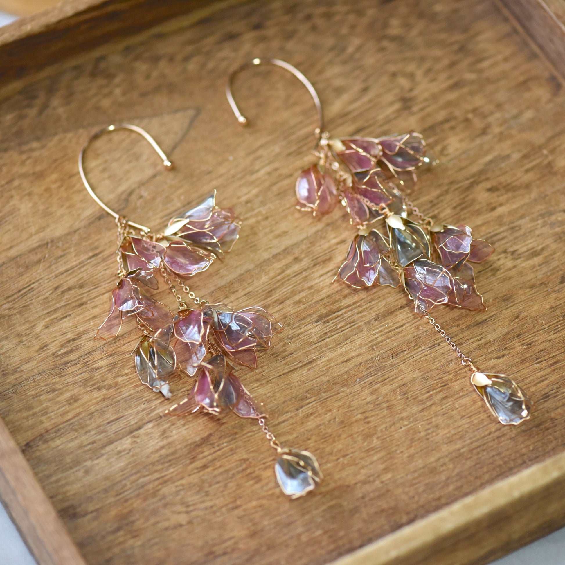 Close-up of Julieta ear cuff showing translucent pink petals edged with fine gold wire