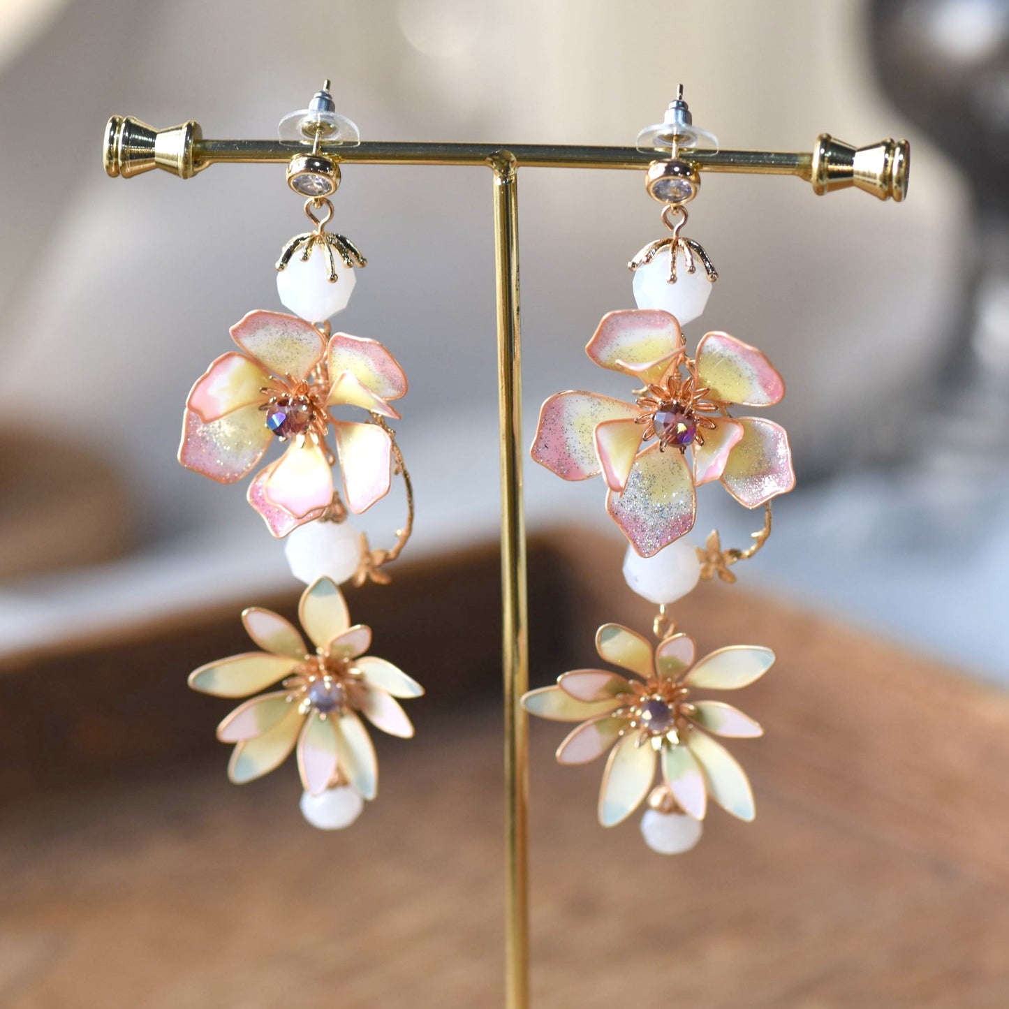Liliana pink and yellow resin floral drop earrings on gold display stand
