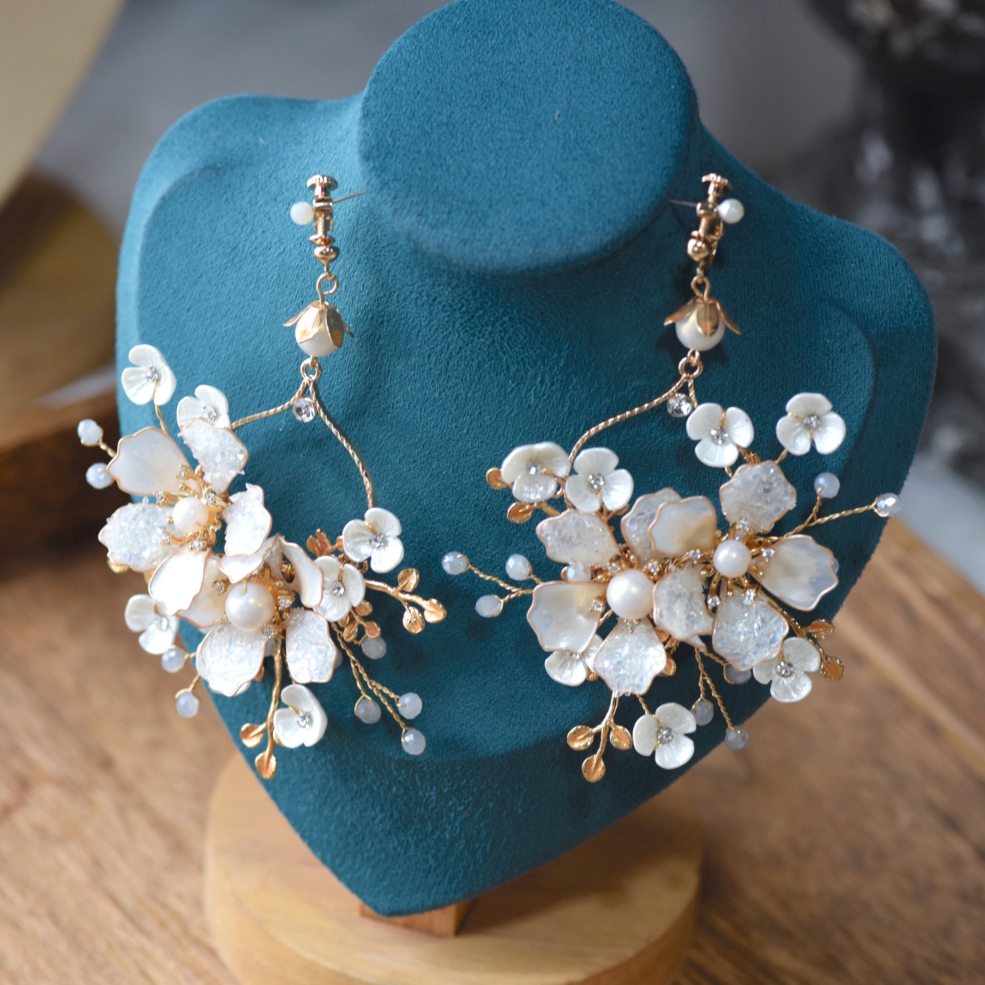 Lorelle handcrafted white resin floral earrings rose gold copper wire on teal bust close-up