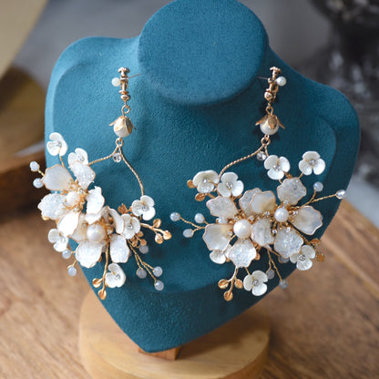 Lorelle handcrafted white resin floral earrings rose gold copper wire on teal bust close-up