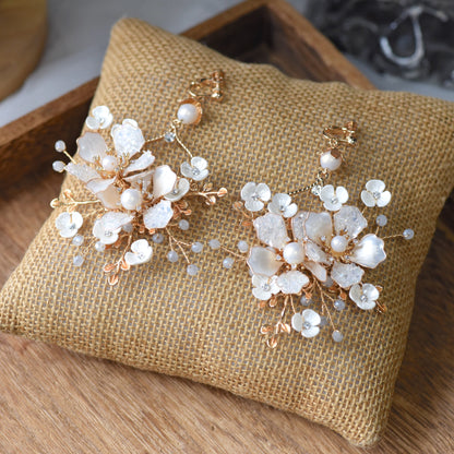 Lorelle handcrafted white resin floral earrings rose gold hints flat lay burlap cushion