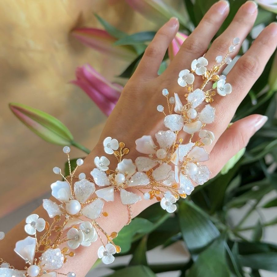 Model wearing Lorelle handcrafted white resin floral haath phool hand harness rose gold bridal look