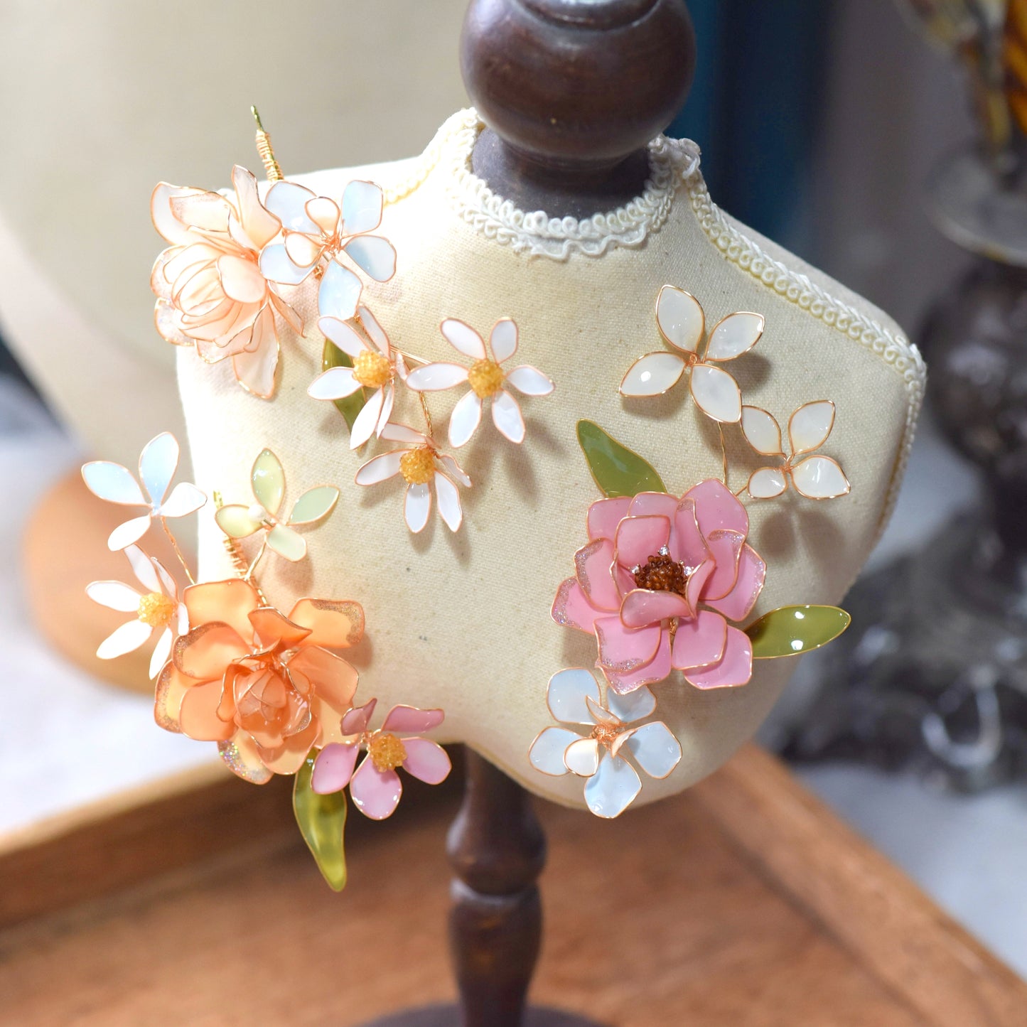 Close-up of Lucia floral hair accessory featuring pastel resin petals and delicate gold wirework