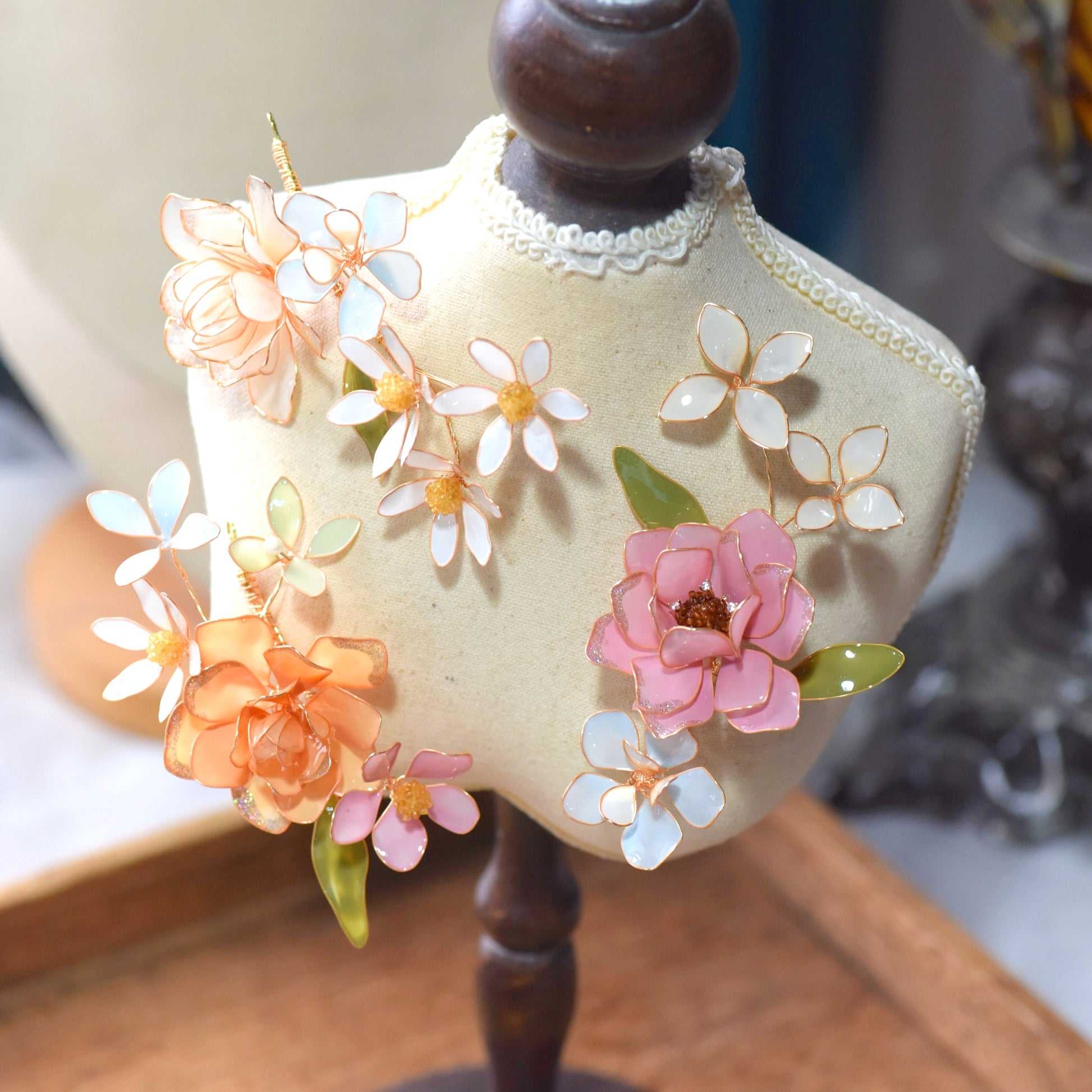 Close-up of Lucia floral hair accessory featuring pastel resin petals and delicate gold wirework