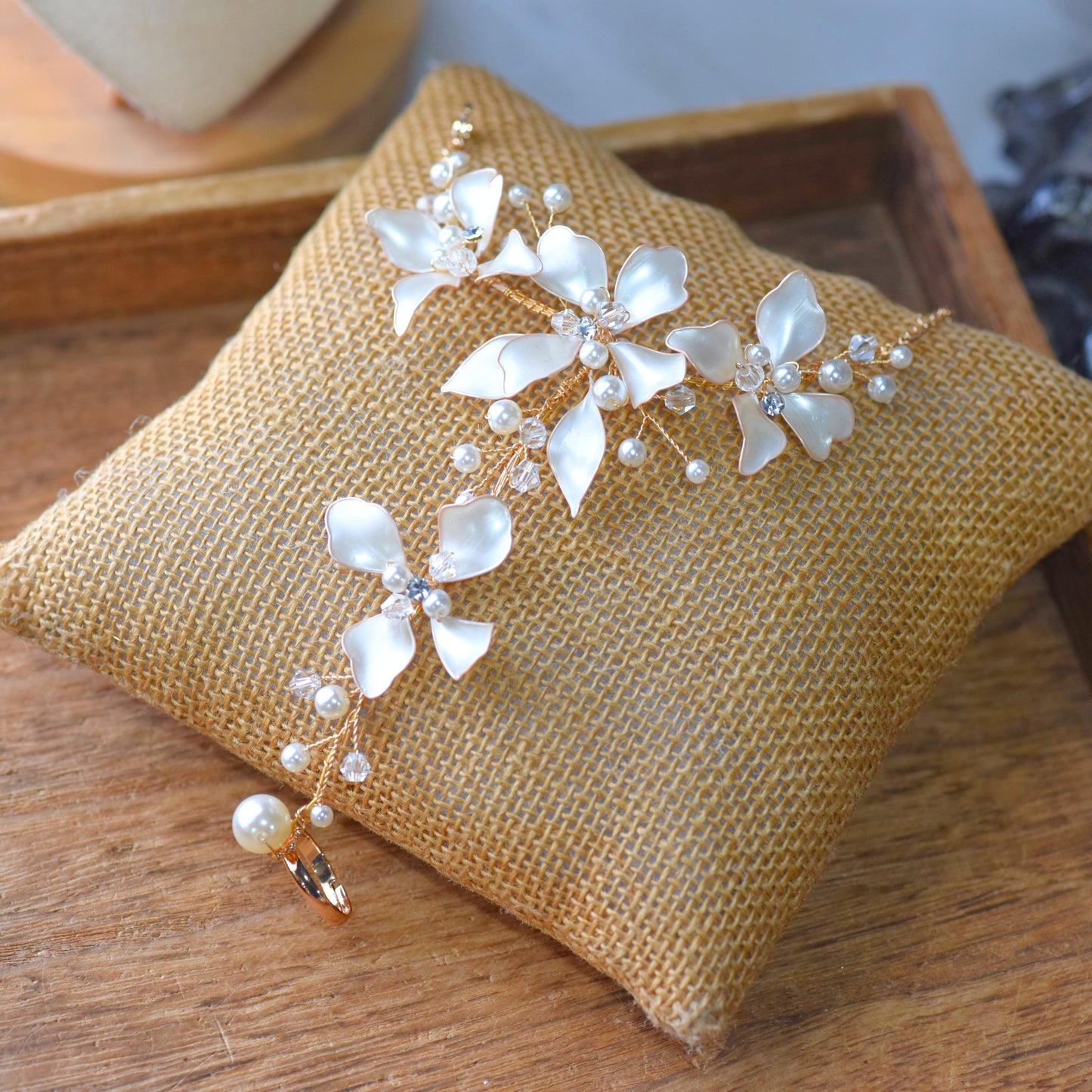 Lunara ivory-white resin floral bridal hand harness haath phool with pearls on jute cushion
