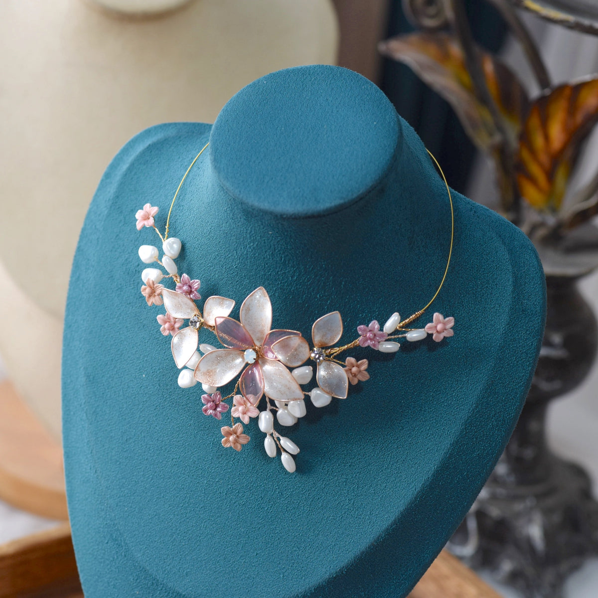 Madeline pink white and lavender resin floral necklace displayed on blue bust
